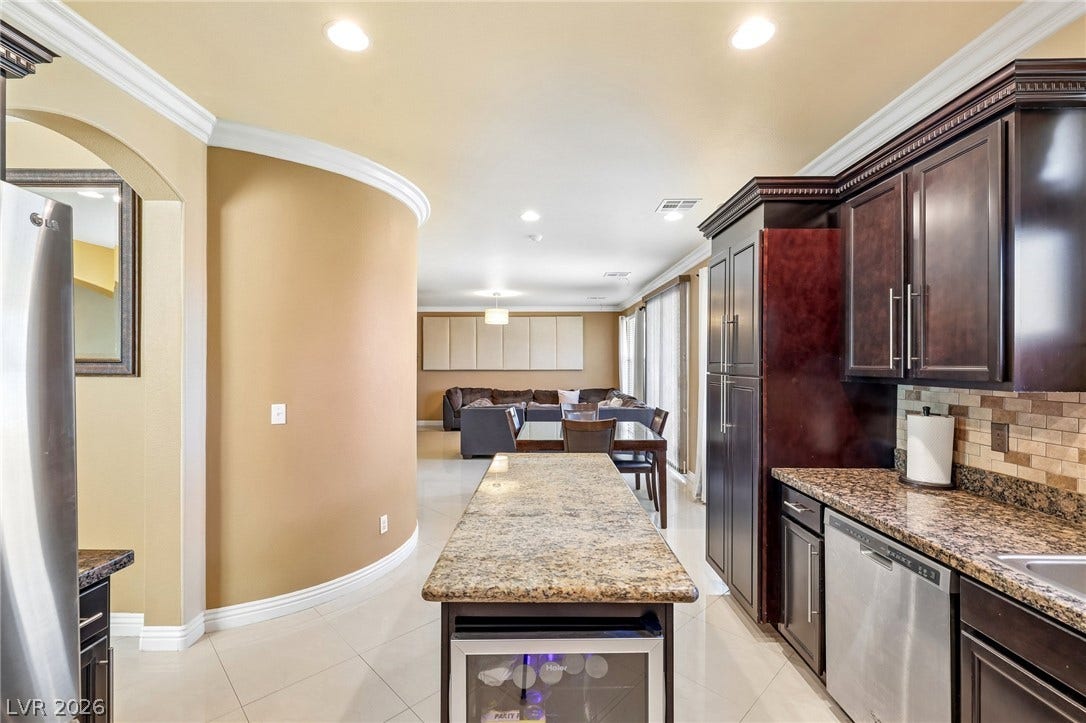 4024 Solar System Street, North Las Vegas, NV 89032 Granite countertops and detailed crown molding enhance this open-concept culinary space.