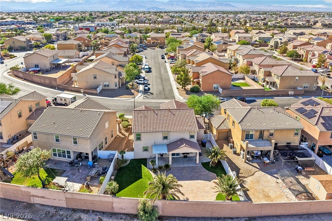 4024 Solar System Street, North Las Vegas, NV 89032 An aerial perspective showcases a neat residential neighborhood framed by distant mountain ranges.