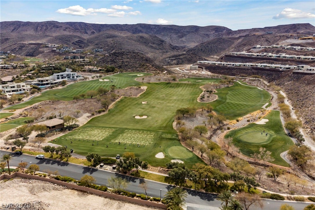 1357 Enchanted River Drive, Henderson, NV 89012 Dramatic mountain ranges frame the rolling fairways of a lush golf course community.