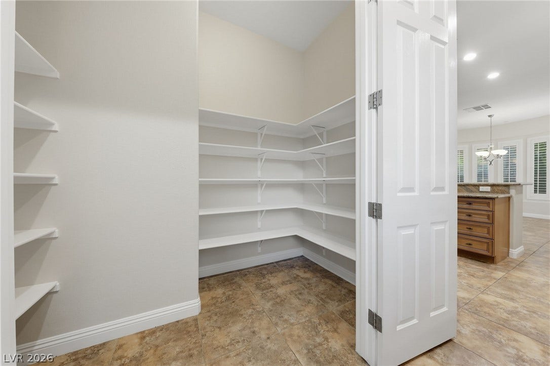 1357 Enchanted River Drive, Henderson, NV 89012 Ample built-in shelving and durable tile flooring define this walk-in kitchen pantry.