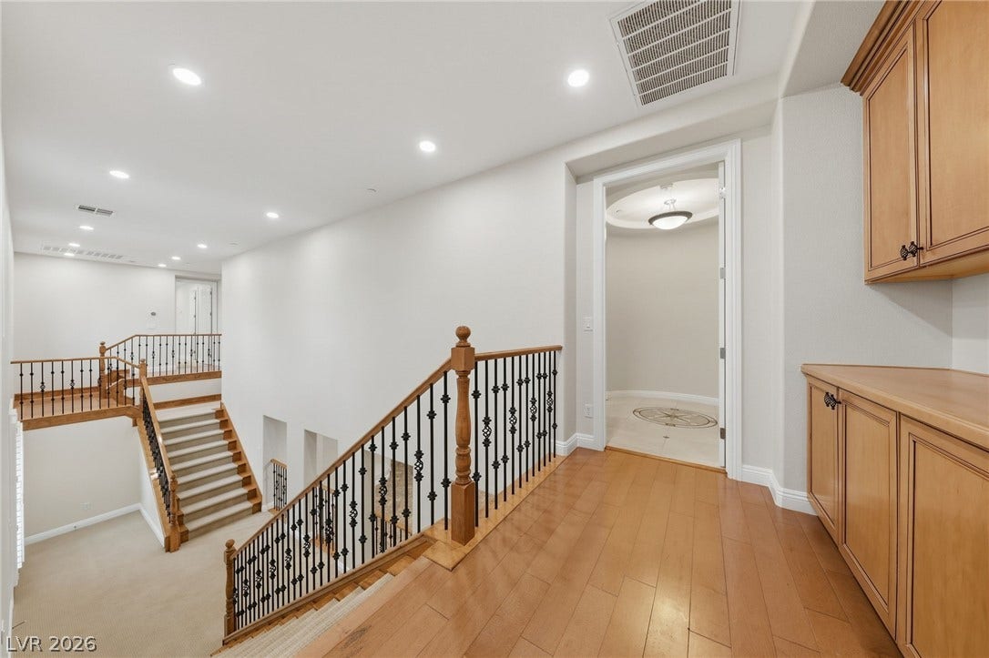 1357 Enchanted River Drive, Henderson, NV 89012 Gleaming hardwood floors and a classic staircase anchor this inviting upper-level landing.
