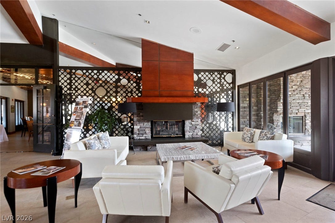 1357 Enchanted River Drive, Henderson, NV 89012 Exposed wood beams and a massive stone fireplace anchor this architectural gathering space.