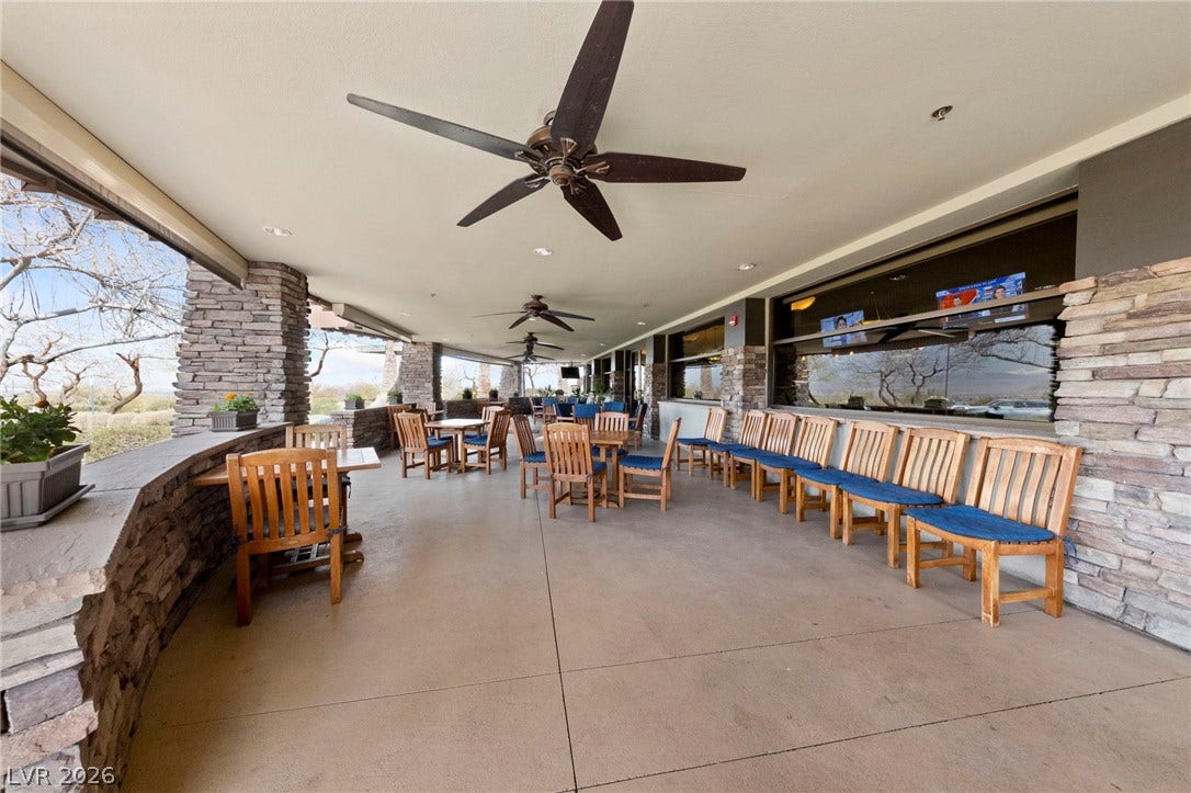 1357 Enchanted River Drive, Henderson, NV 89012 Sheltered outdoor seating area enhanced by stone pillars and expansive concrete flooring.