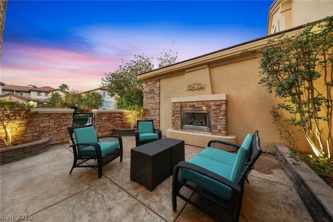 1357 Enchanted River Drive, Henderson, NV 89012 An inviting outdoor fireplace highlights this stamped concrete patio surrounded by stone masonry walls.