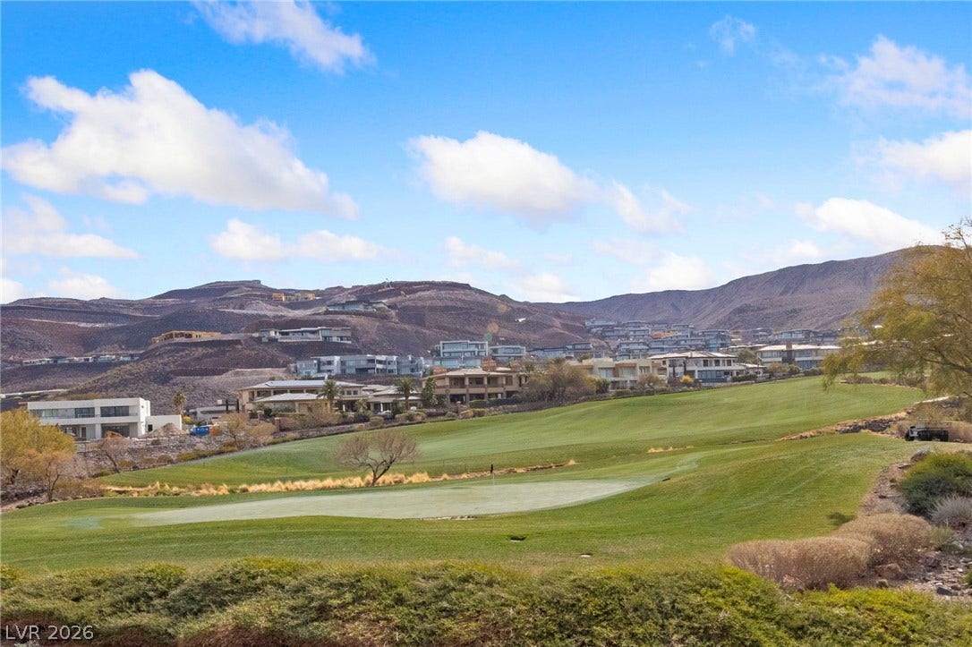 1357 Enchanted River Drive, Henderson, NV 89012 Lush fairways yield to rugged mountain peaks under a vast blue sky.