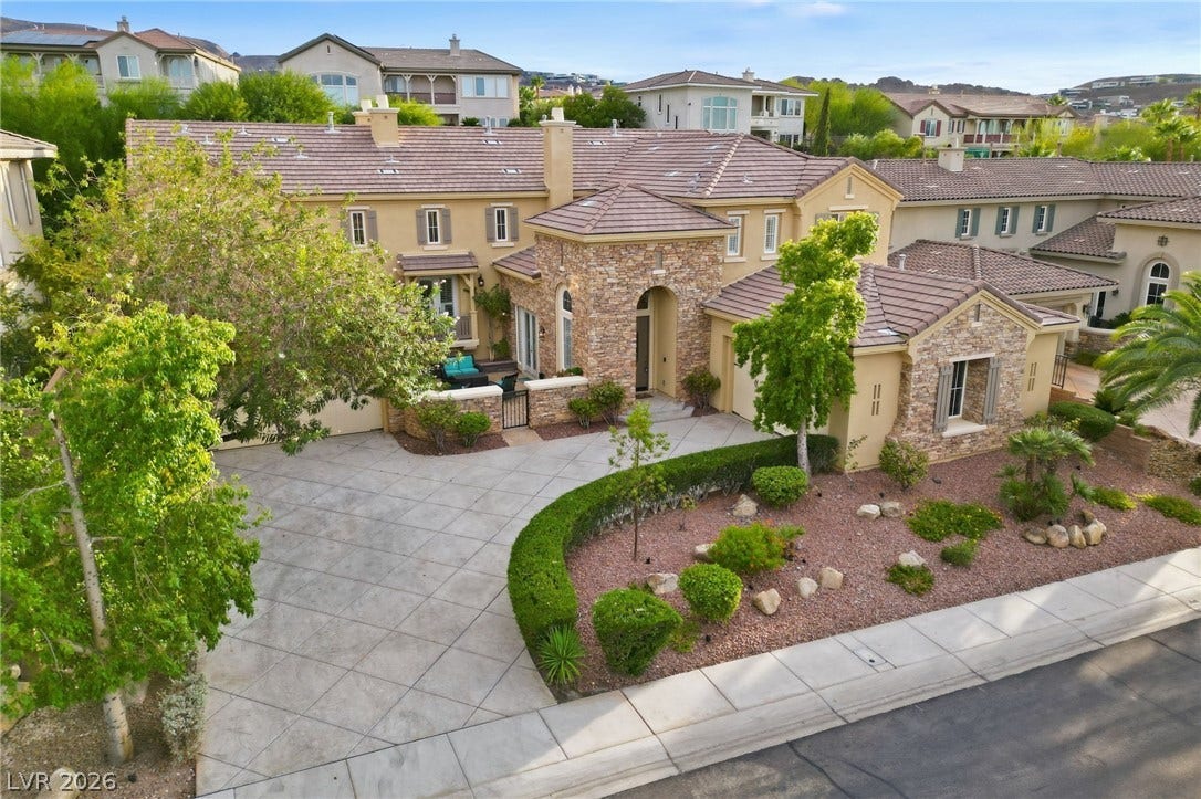 1357 Enchanted River Drive, Henderson, NV 89012 A spacious stamped concrete driveway leads to this stone-accented home featuring a beautifully landscaped front courtyard.