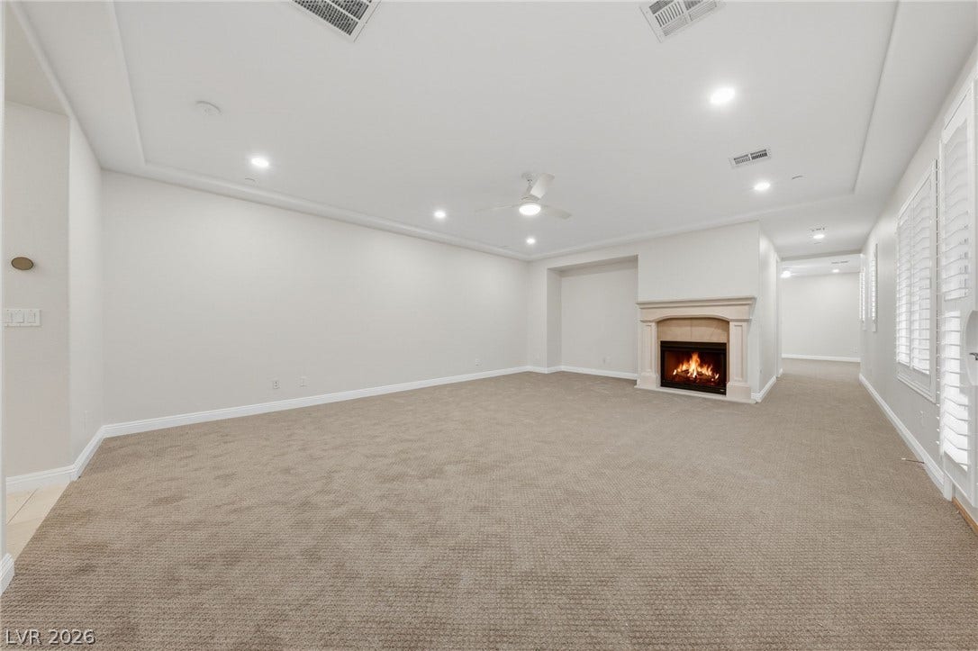 1357 Enchanted River Drive, Henderson, NV 89012 Plush carpeting and a cozy fireplace anchor this generous living space.