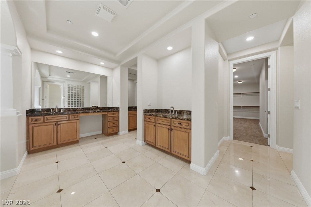 1357 Enchanted River Drive, Henderson, NV 89012 Gleaming tile floors and custom cabinetry anchor this elegant master bathroom retreat.
