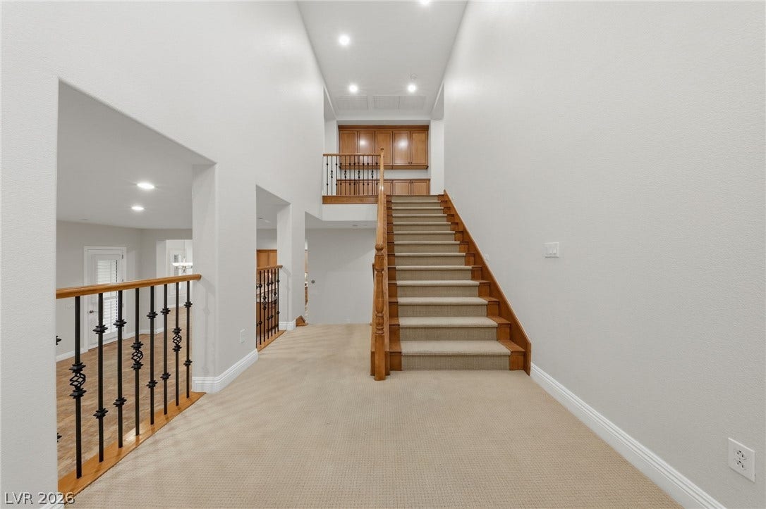 1357 Enchanted River Drive, Henderson, NV 89012 A spacious carpeted landing connects the levels alongside a classic wooden staircase.