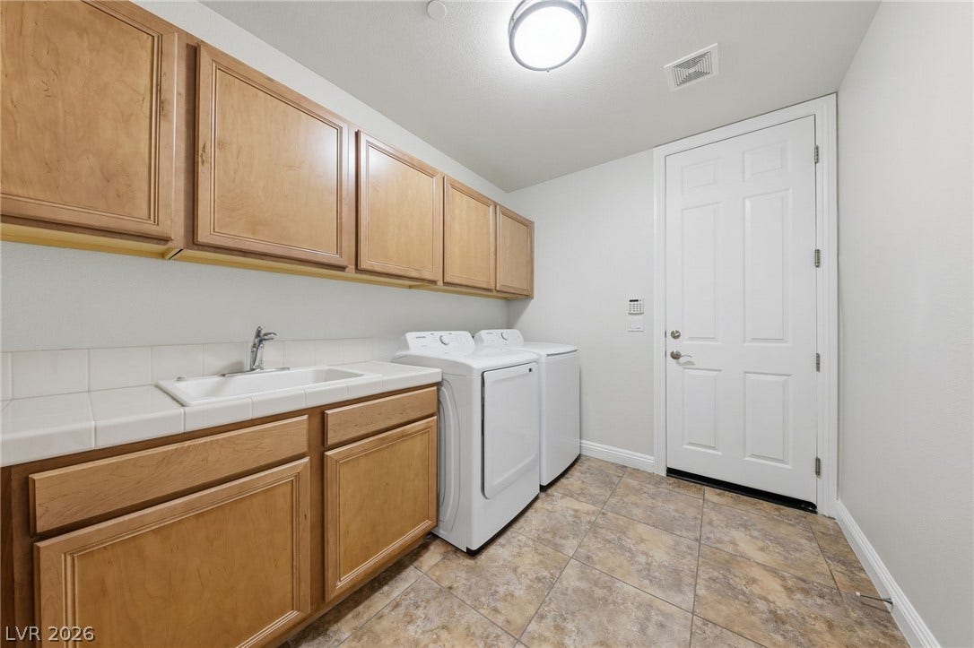 1357 Enchanted River Drive, Henderson, NV 89012 Ample wooden cabinetry and durable tile flooring define this highly functional utility space.