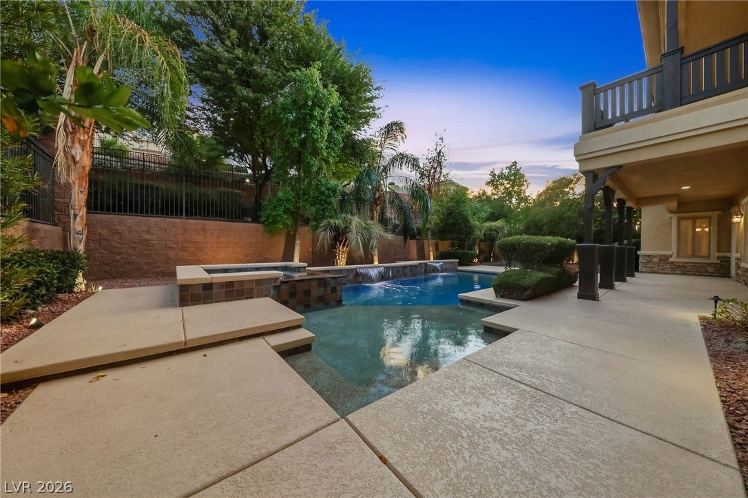 1357 Enchanted River Drive, Henderson, NV 89012 Lush landscaping and expansive concrete decking surround a sparkling custom pool and elevated spa.
