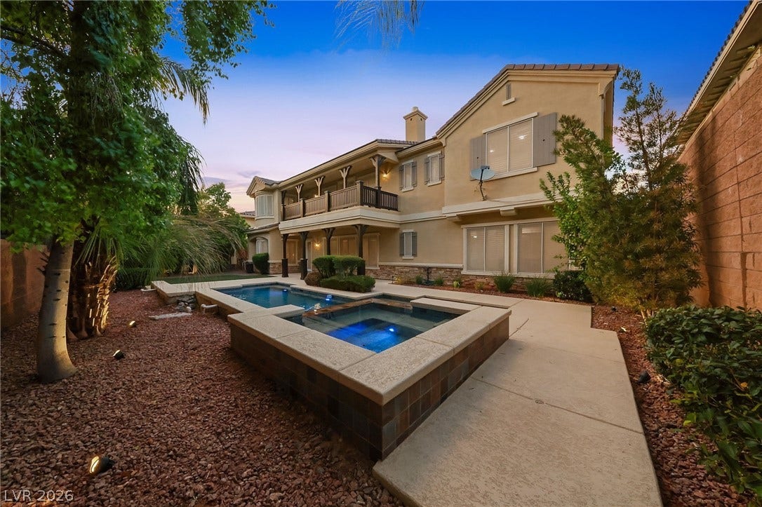 1357 Enchanted River Drive, Henderson, NV 89012 A sparkling pool and spa anchor this backyard retreat against a classic stucco exterior.