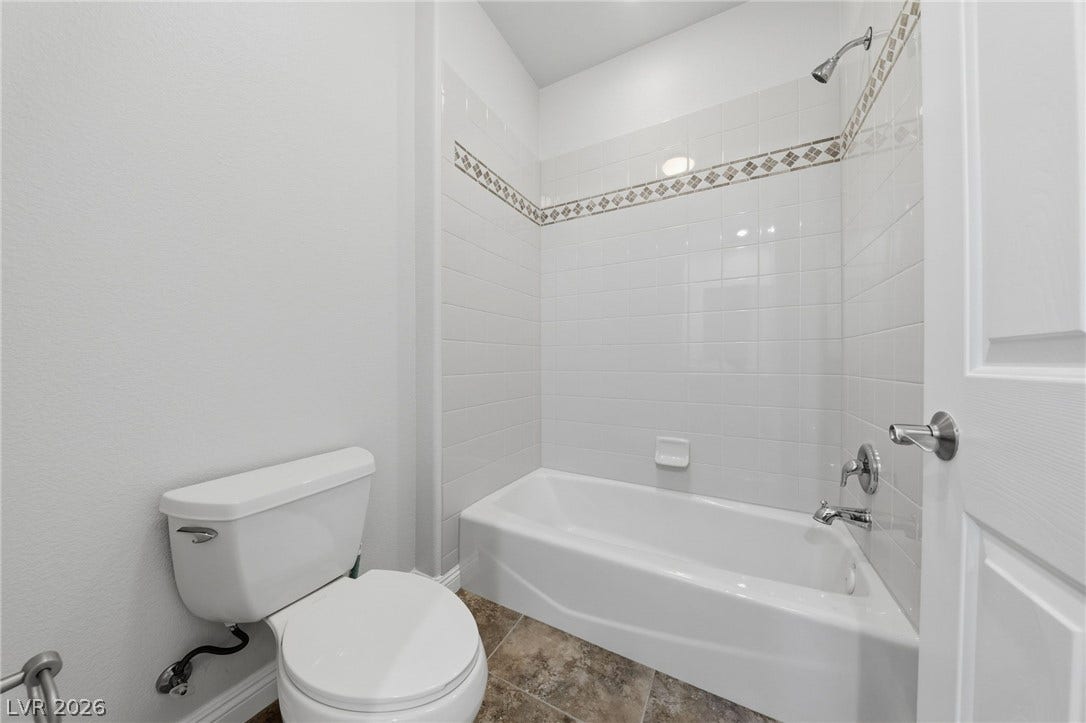 1357 Enchanted River Drive, Henderson, NV 89012 Tiled walls and classic fixtures define this inviting bathroom space.