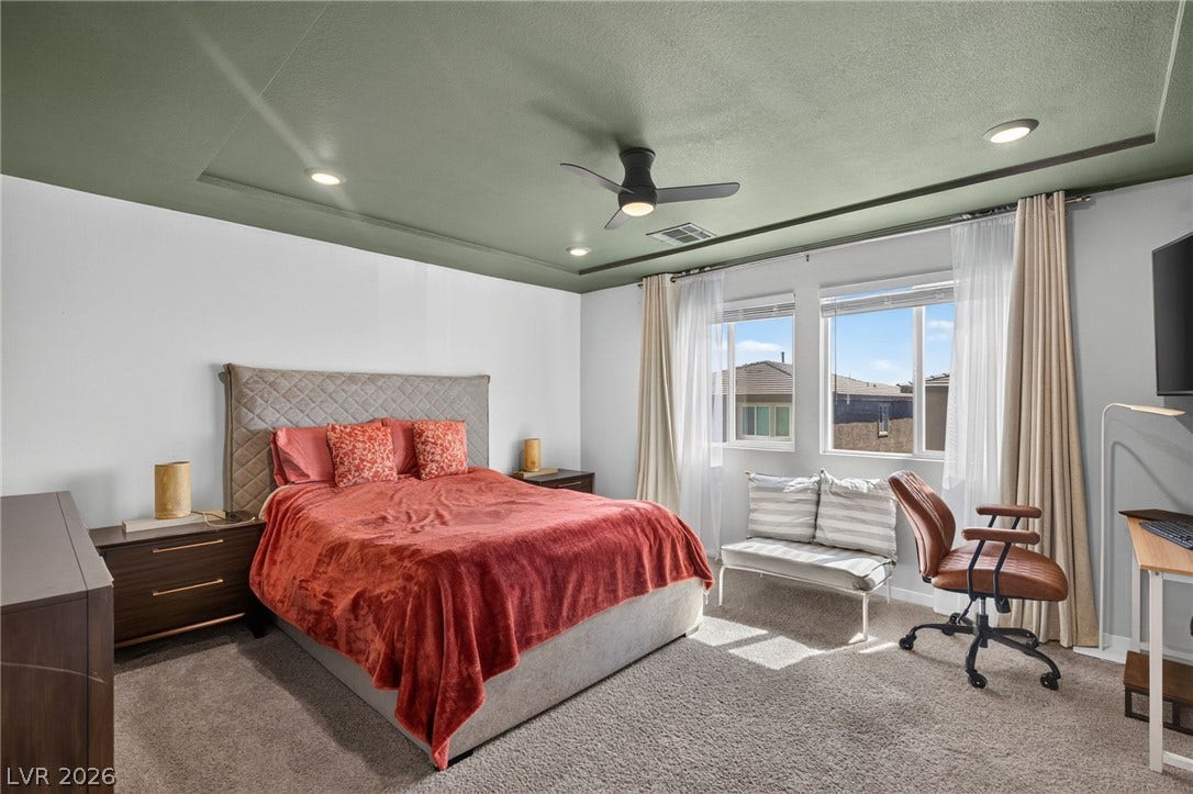 2719 High Echelon Road, North Las Vegas, NV 89086 Plentiful natural light streams through wide windows over soft carpeting in this bedroom.