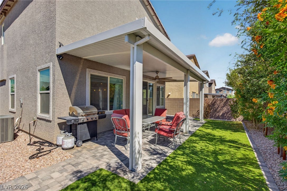 2719 High Echelon Road, North Las Vegas, NV 89086 A spacious covered patio features clean pavers and overlooks the manicured lawn area.