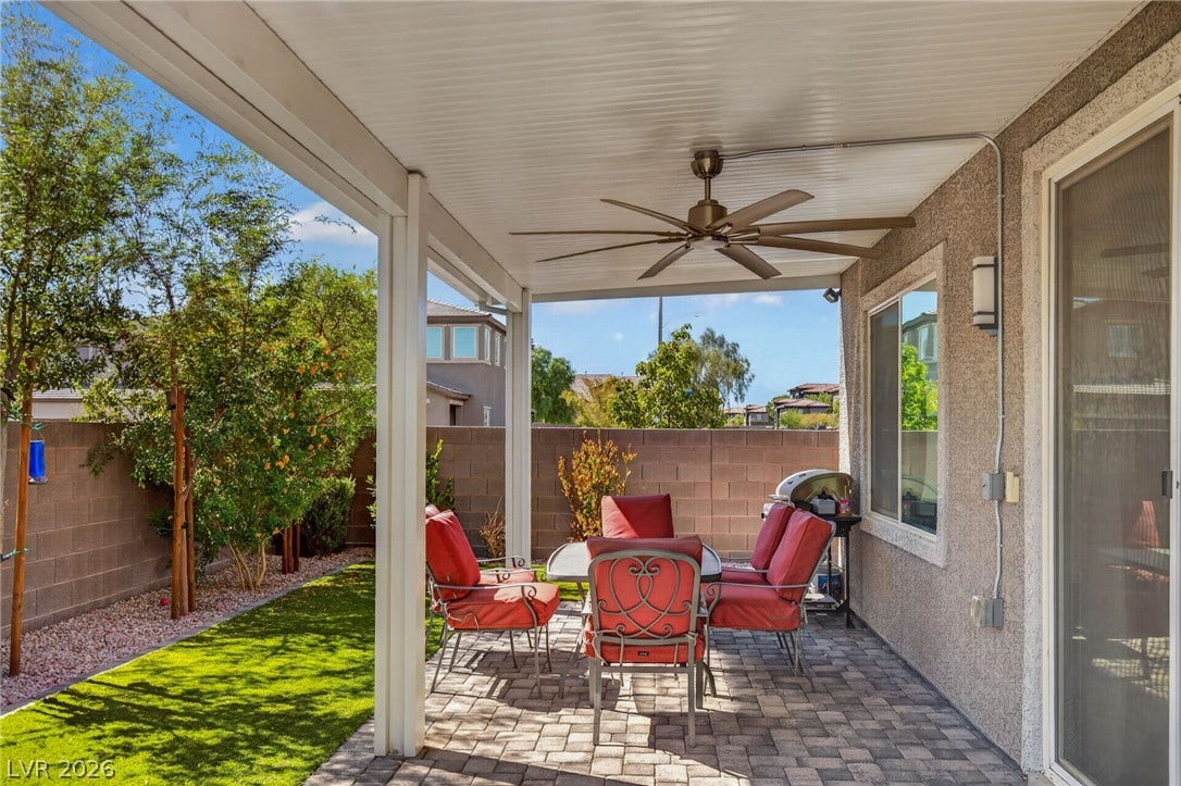 2719 High Echelon Road, North Las Vegas, NV 89086 A sheltered paver patio provides comfortable outdoor living space adjacent to a neat lawn.