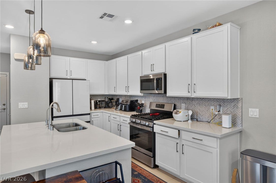 2719 High Echelon Road, North Las Vegas, NV 89086 Crisp white cabinetry pairs perfectly with stone countertops in this modern culinary space.
