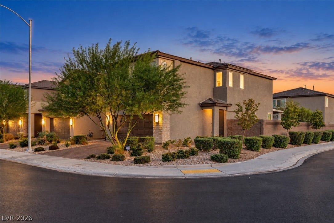 2719 High Echelon Road, North Las Vegas, NV 89086 A contemporary multi-story exterior features desert landscaping and paved driveways under a warm sunset sky.