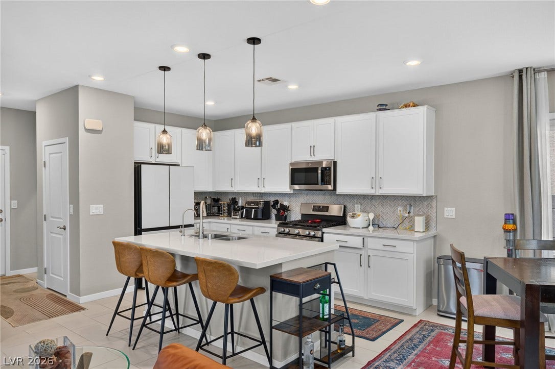2719 High Echelon Road, North Las Vegas, NV 89086 Gleaming stone countertops and white cabinetry define this modern culinary space.