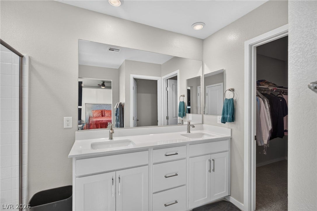 2719 High Echelon Road, North Las Vegas, NV 89086 A spacious double vanity paired with modern recessed lighting guides the way to the walk-in closet.