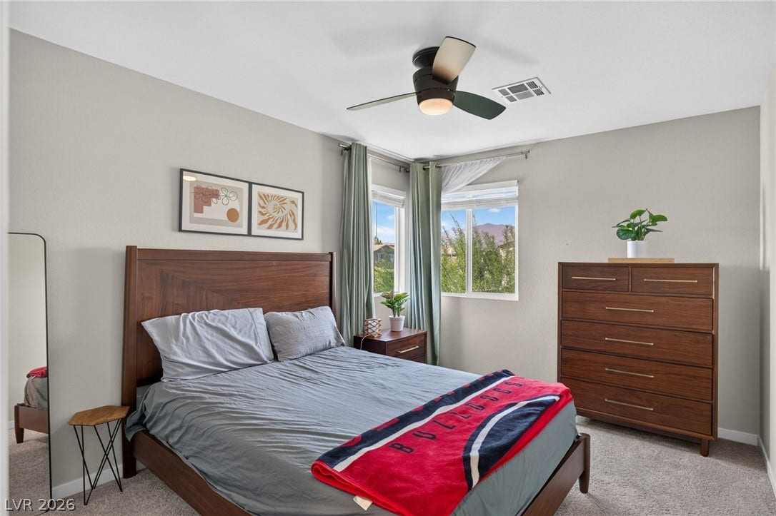 2719 High Echelon Road, North Las Vegas, NV 89086 Double windows frame tranquil neighborhood views from this cozy carpeted bedroom.