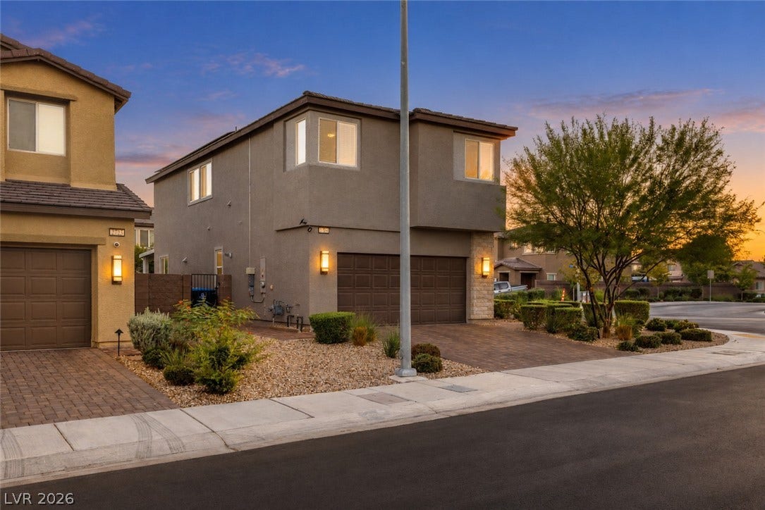 2719 High Echelon Road, North Las Vegas, NV 89086 An inviting exterior displays stone details and paved driveways under a warm evening sky.