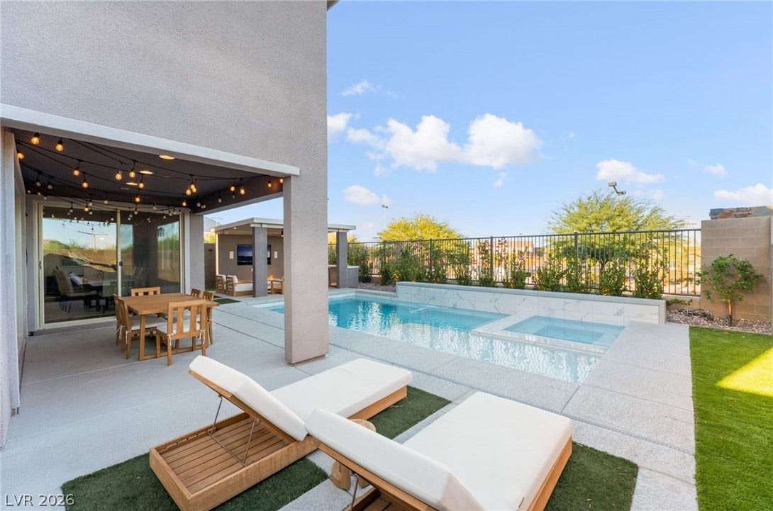 12424 Point Sierra Street, Las Vegas, NV 89138 An inviting backyard oasis features a clean-lined swimming pool, integrated spa, and spacious covered patio.