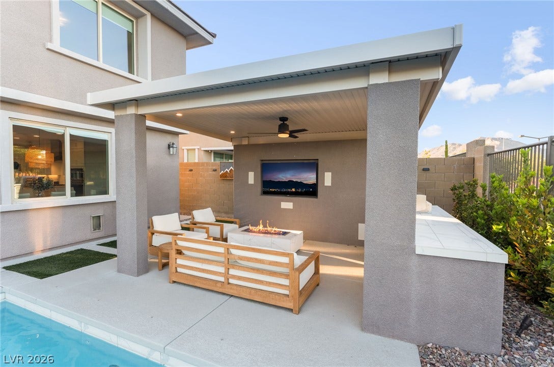 12424 Point Sierra Street, Las Vegas, NV 89138 A covered concrete patio sits adjacent to the pool with a built-in outdoor media wall.