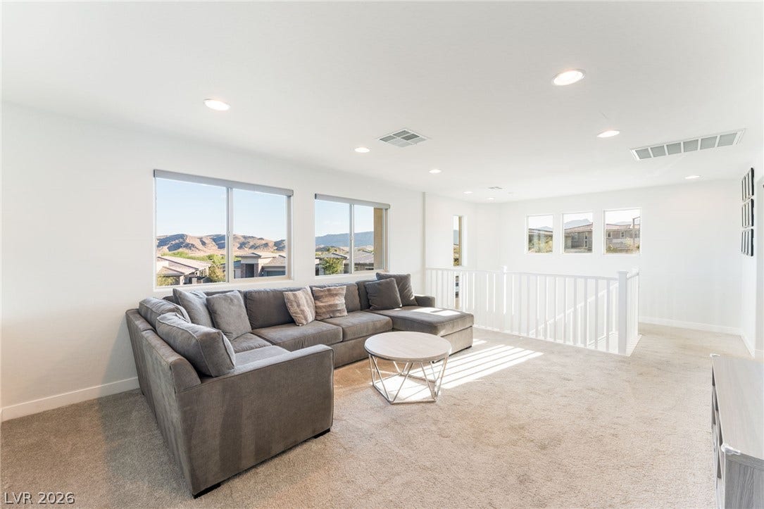 12424 Point Sierra Street, Las Vegas, NV 89138 Large windows frame scenic mountain views from this upper-level living space.