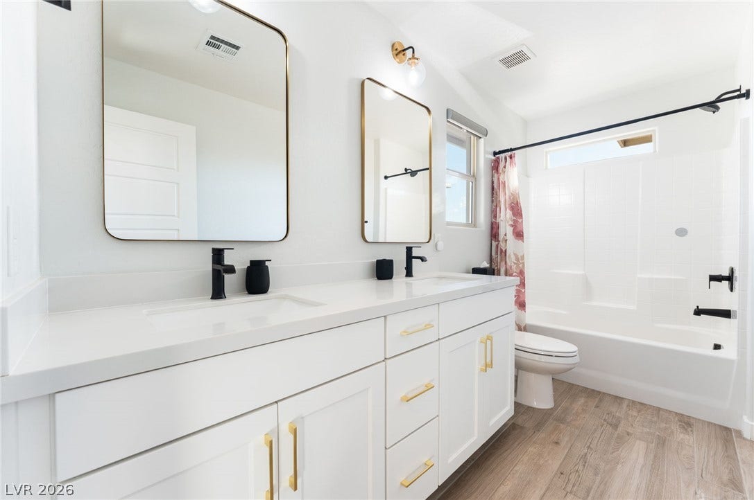 12424 Point Sierra Street, Las Vegas, NV 89138 Clean lines and a spacious double vanity define this modern bathroom with wood-look flooring.