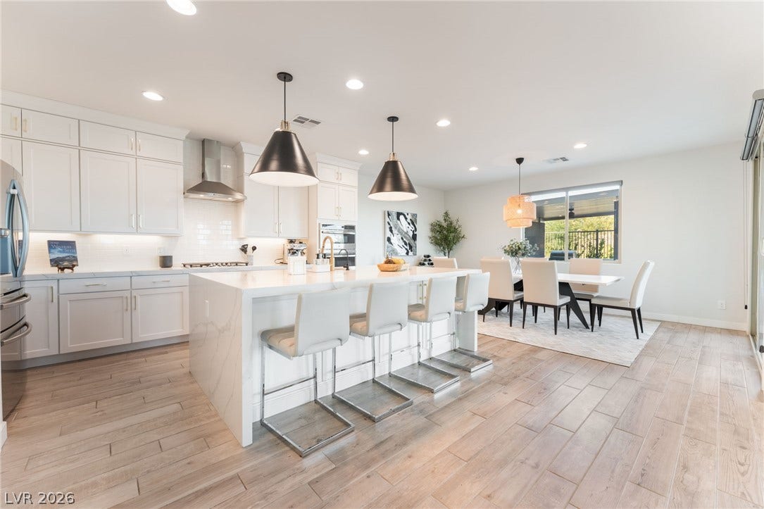 12424 Point Sierra Street, Las Vegas, NV 89138 An open floorplan seamlessly connects the modern kitchen and dining area under recessed lighting.