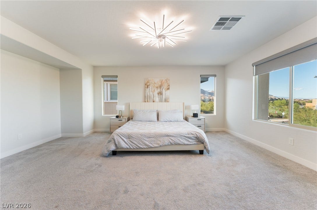12424 Point Sierra Street, Las Vegas, NV 89138 Generous windows frame neighborhood views in this light-filled bedroom with plush carpeting.