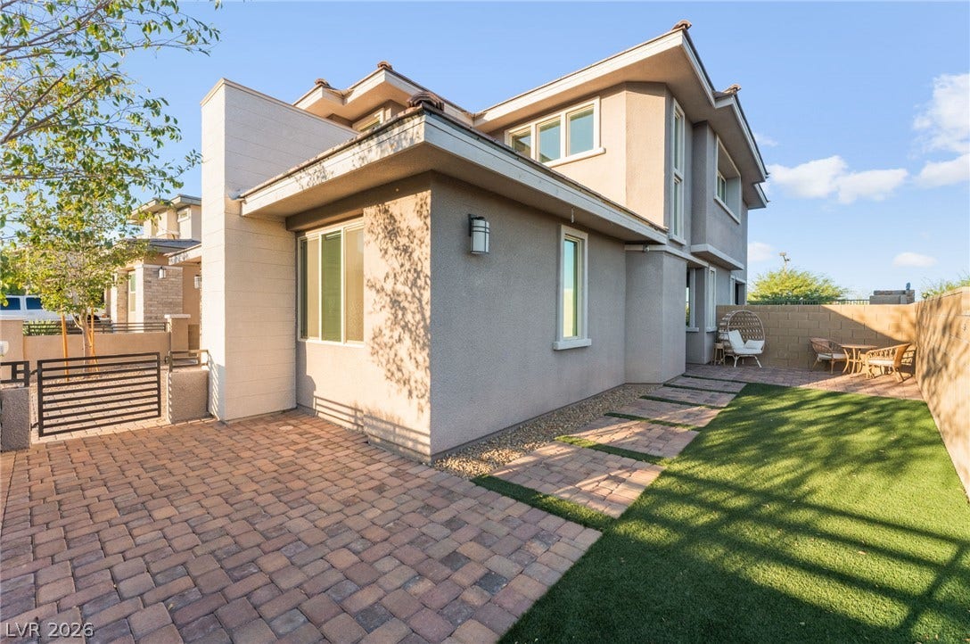 12424 Point Sierra Street, Las Vegas, NV 89138 Brick pavers and green lawns frame the exterior of this modern multi-level stucco home.