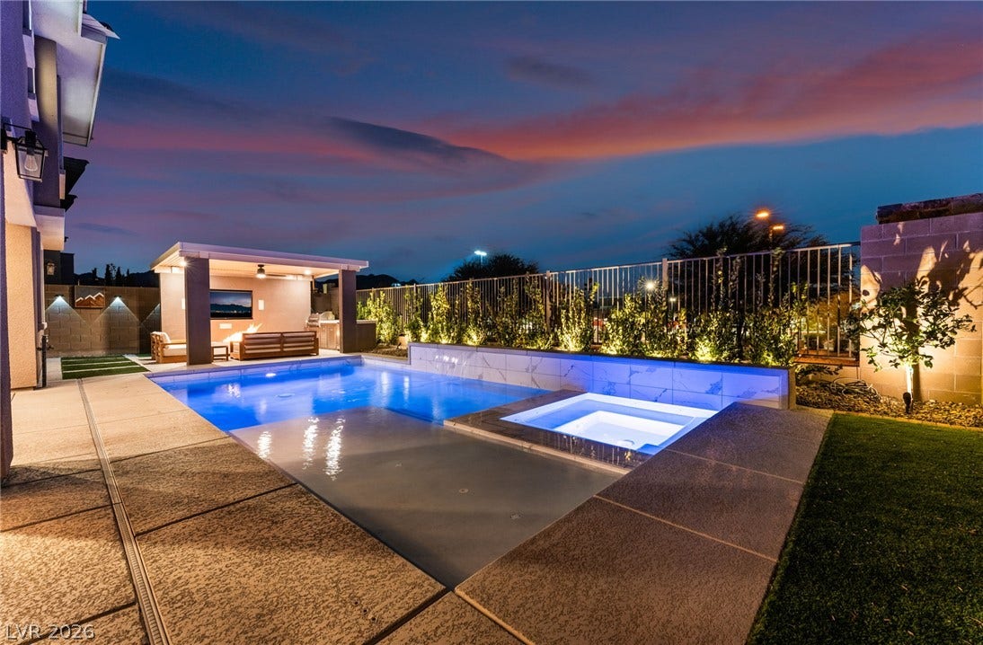 12424 Point Sierra Street, Las Vegas, NV 89138 An inviting backyard oasis features a gleaming pool and spa under a twilight sky.
