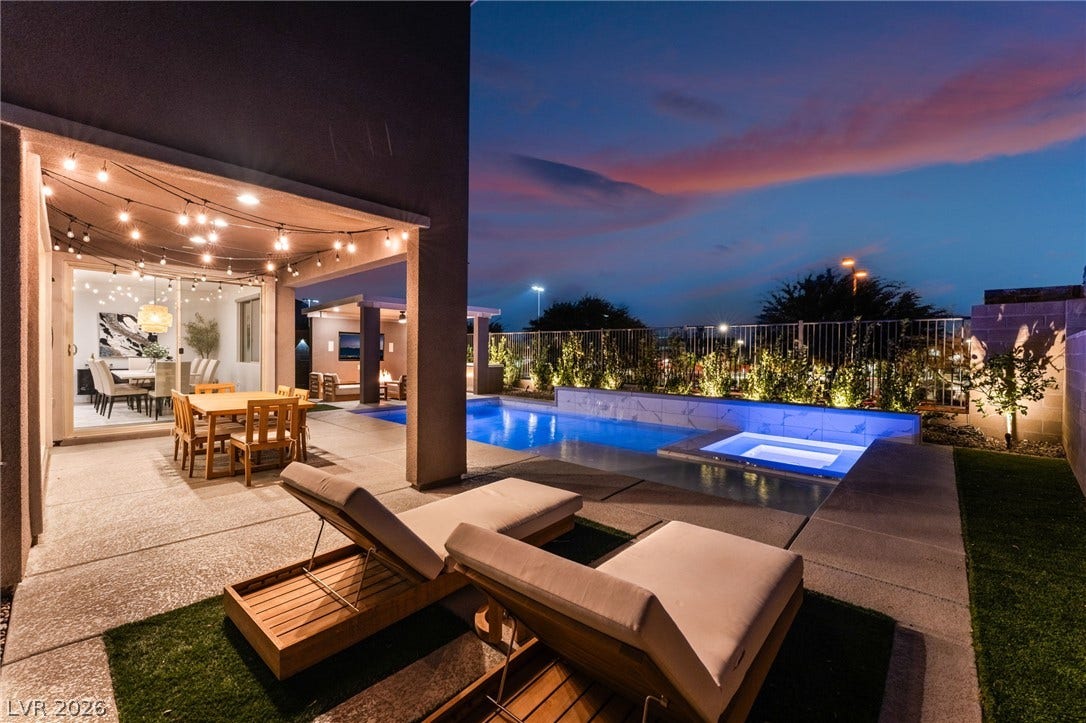 12424 Point Sierra Street, Las Vegas, NV 89138 An inviting backyard oasis features a gleaming pool, spa, and covered patio under twilight skies.
