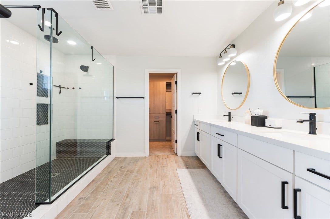 12424 Point Sierra Street, Las Vegas, NV 89138 A spacious double vanity and a glass-enclosed walk-in shower elevate this modern bathroom.