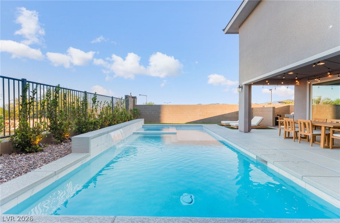 12424 Point Sierra Street, Las Vegas, NV 89138 An inviting swimming pool and spa lie adjacent to a shaded patio and clean hardscaping.