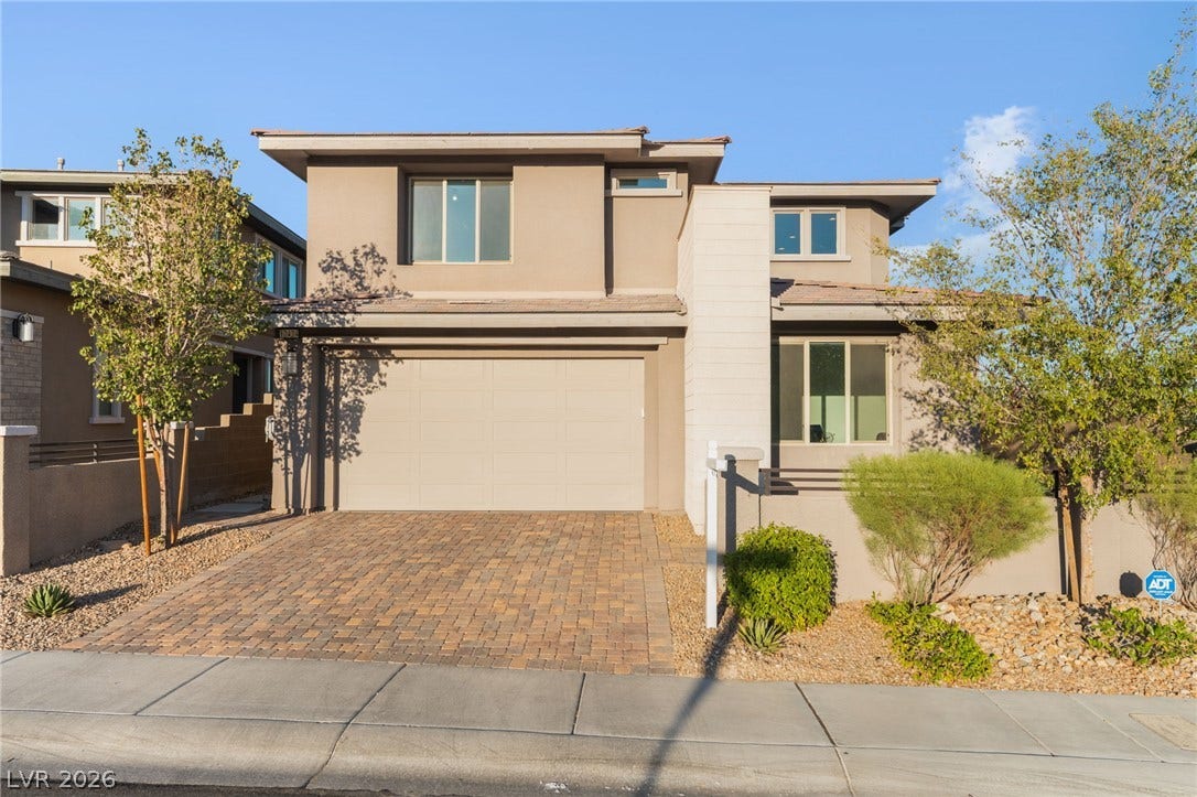 12424 Point Sierra Street, Las Vegas, NV 89138 A modern two-story exterior showcases stucco finishes alongside a handsome paver driveway.