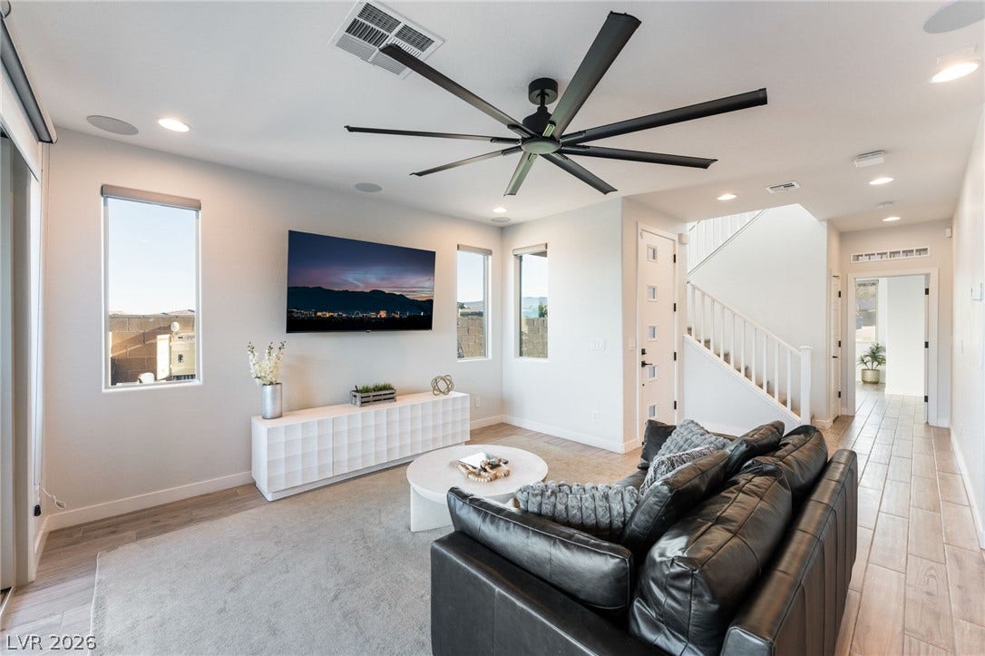 12424 Point Sierra Street, Las Vegas, NV 89138 Recessed lighting and warm wood-look tile flooring enhance this open-concept living space.