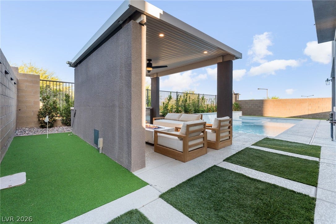 12424 Point Sierra Street, Las Vegas, NV 89138 A covered concrete patio sits adjacent to a private swimming pool in this fenced backyard.
