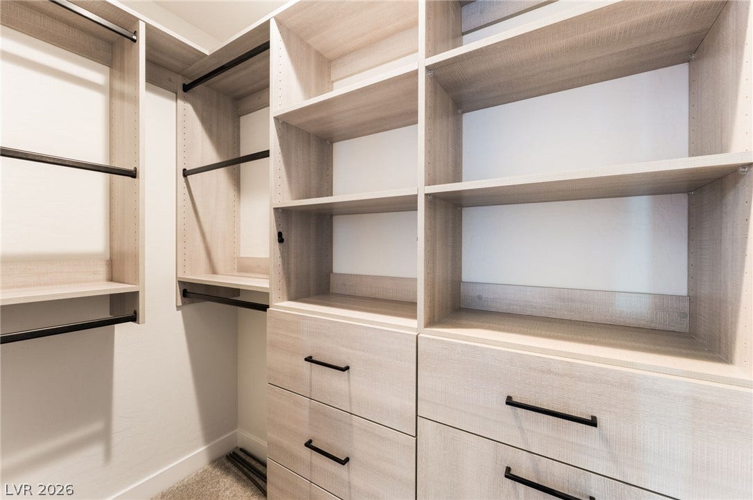 12424 Point Sierra Street, Las Vegas, NV 89138 Custom built-in shelving and ample drawer storage maximize organization in this modern walk-in closet.