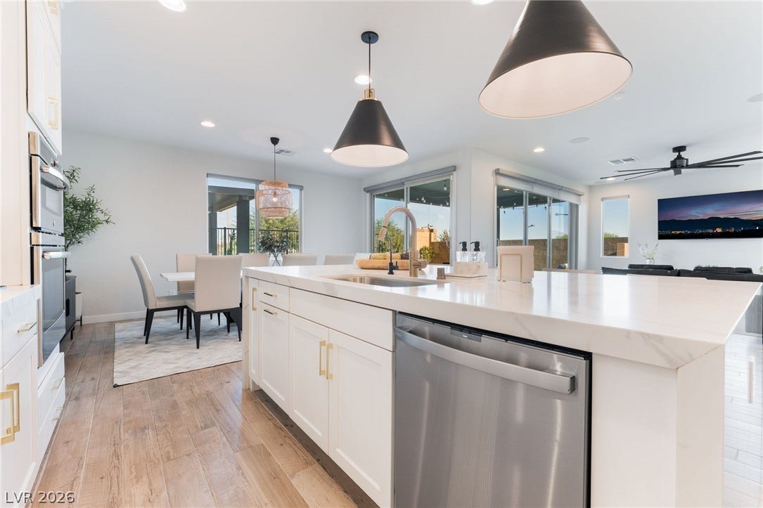 12424 Point Sierra Street, Las Vegas, NV 89138 Gleaming stone countertops and warm wood floors define this bright, airy kitchen design.