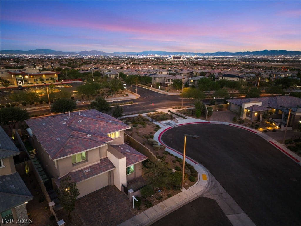 12424 Point Sierra Street, Las Vegas, NV 89138 An elevated perspective captures the modern tile roof design against distant city lights and mountain peaks.