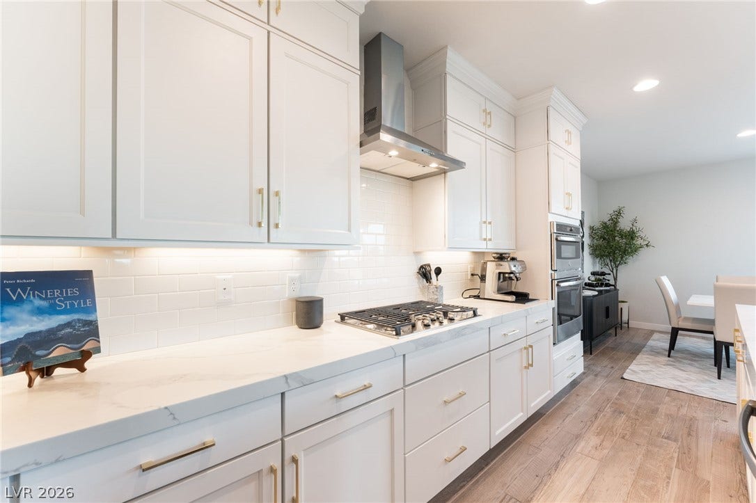 12424 Point Sierra Street, Las Vegas, NV 89138 Polished stone counters and custom cabinetry define this modern open-concept culinary space.