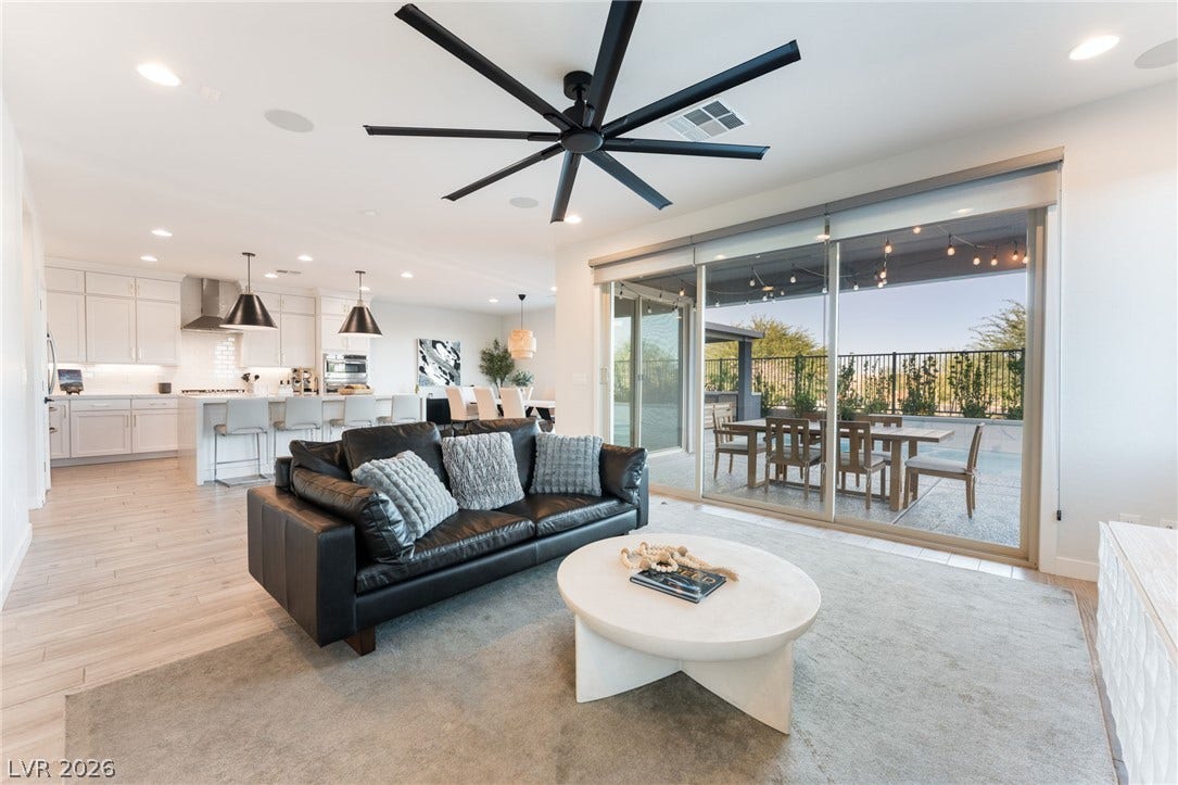 12424 Point Sierra Street, Las Vegas, NV 89138 Sunlight streams through sliding glass doors into a modern, open-concept living area.
