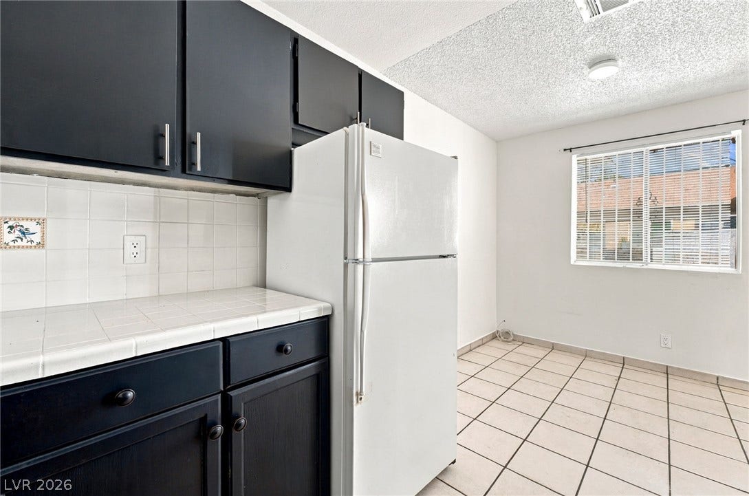 2553 Ellis Street, North Las Vegas, NV 89030 Tiled flooring and dark cabinetry define this functional kitchen and dining space.?