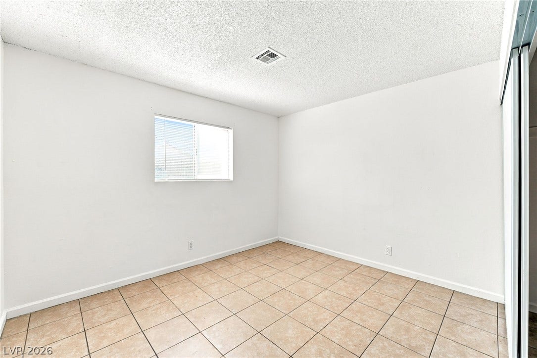 2553 Ellis Street, North Las Vegas, NV 89030 Tiled flooring and natural light from a central window define this versatile bedroom space.