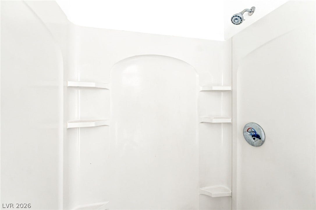 2553 Ellis Street, North Las Vegas, NV 89030 A clean shower enclosure includes integrated shelving and classic chrome fixtures.
