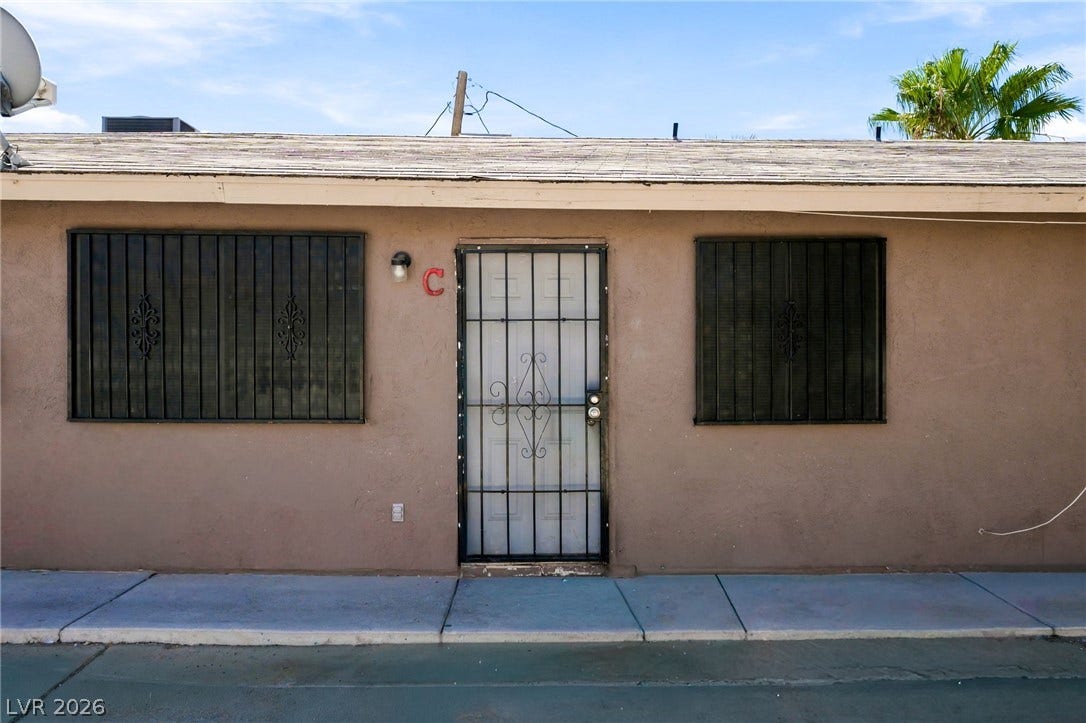 2553 Ellis Street, North Las Vegas, NV 89030 Stucco exterior features security bars over the windows and a matching gated entry door.
