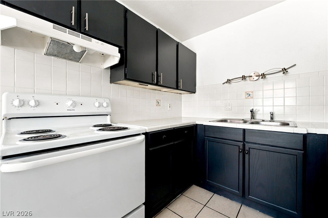 2553 Ellis Street, North Las Vegas, NV 89030 Contrast cabinetry and clean tile counters define this functional cooking space.